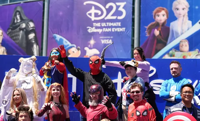 Marvel Universe cosplayers take part in a photo op outside the entrance to D23: The Ultimate Disney Fan Event on Friday, Aug. 14, 2026, at the Anaheim Convention Center in Anaheim, Calif. (AP Photo/Chris Pizzello)