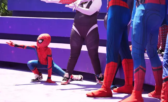 Daniel Delgado, 6, of Victorville, Calif., joins a photo op for cosplayers dressed as "Spider-Man" during D23: The Ultimate Disney Fan Event on Friday, Aug. 14, 2026, at the Anaheim Convention Center in Anaheim, Calif. (AP Photo/Chris Pizzello)