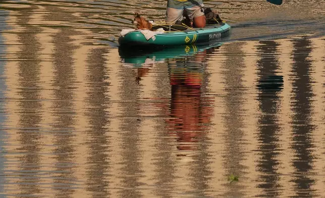 A man and his dog move along Lady Bird Lake on a paddle board in Austin, Texas, Wednesday, Aug. 5, 2026. (AP Photo/Eric Gay)