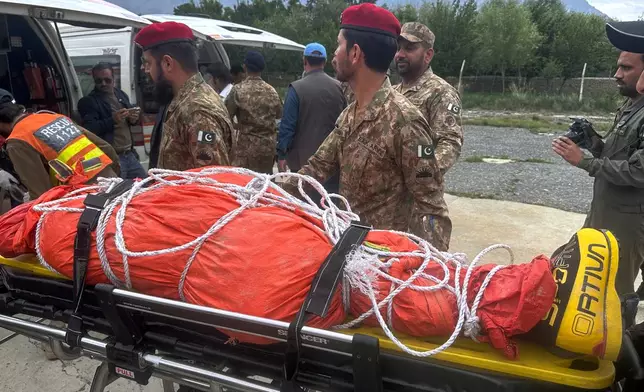 Pakistani army soldiers prepare to load into an ambulance, the body of renowned British-Nepali mountaineer Nirmal Purja, that was recovered from Broad Peak nearly a week after an avalanche swept away a 10-member international expedition, upon arrival at military base in Skardu, in northern Pakistan, Thursday, Aug 6, 2026. (AP Photo/ M.H. Balti)