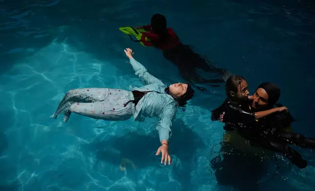 Rimas Abu Shalouf, 16, who lost both legs after being injured during the war between Israel and Hamas, receives swimming training from the Heal Palestine organization at a pool in Khan Younis, Gaza Strip, Wednesday, Aug. 19, 2026. (AP Photo/Abdel Kareem Hana)