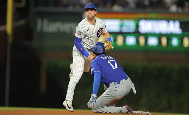 Chicago Cubs' Nico Hoerner throws into second base for a double during the sixth inning of a baseball game against the Los Angeles Dodgers, Tuesday, Aug. 4, 2026, in Chicago. (AP Photo/Melissa Tamez)