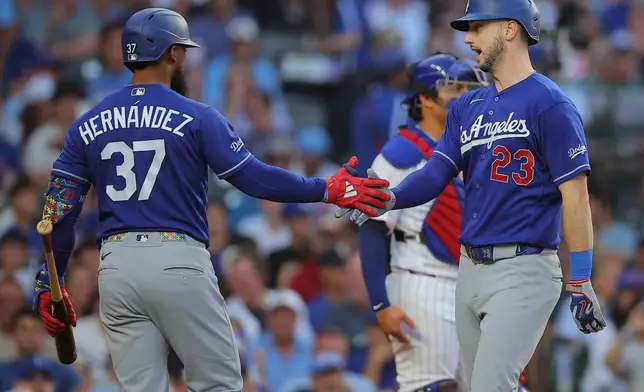 Los Angeles Dodgers' Kyle Tucker, right, celebrates with teammate Teoscar Hernández after hitting a home run during the second inning of a baseball game against the Chicago Cubs, Tuesday, Aug. 4, 2026, in Chicago. (AP Photo/Melissa Tamez)