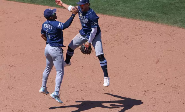 Tampa Bay Rays' Richie Palacios (1) and Taylor Walls, right, celebrate after the final out of a baseball game as the Rays defeat the Athletics Wednesday, Aug. 12, 2026, in West Sacramento, Calif. (AP Photo/Scott Marshall)