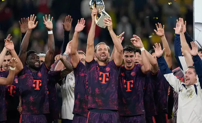 Bayern's Harry Kane lifts the trophy after winning the Franz Beckenbauer German Supercup soccer match against Borussia Dortmund in Dortmund, Germany, Saturday, Aug. 22, 2026. (AP Photo/Martin Meissner)