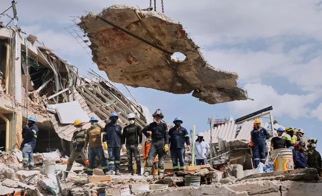 A crane lifts a concrete slab to clear the way for rescuers searching through the rubble three days after an earthquake hit Pereira, Colombia, Thursday, Aug. 13, 2026. (AP Photo/Brandon Pinto)
