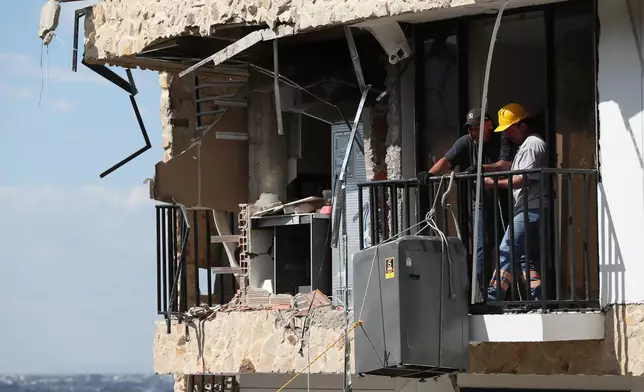 People remove a washing machine from an earthquake-damaged home three days after a quake hit Cali, Colombia, Thursday, Aug. 13, 2026. (AP Photo/Santiago Saldarriaga)