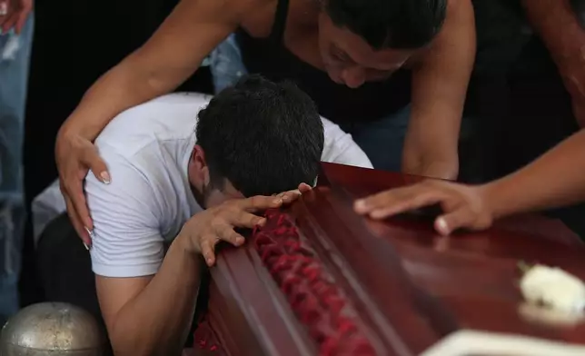 Relative mourn during the funeral of Lorena Restrepo who died at her home when an earthquake hit Cali, Colombia, Friday, Aug. 14, 2026. (AP Photo/Santiago Saldarriaga)