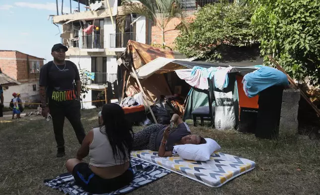 People camp on a soccer field near their earthquake-damaged homes three days after a quake hit Cali, Colombia, Thursday, Aug. 13, 2026. (AP Photo/Santiago Saldarriaga)