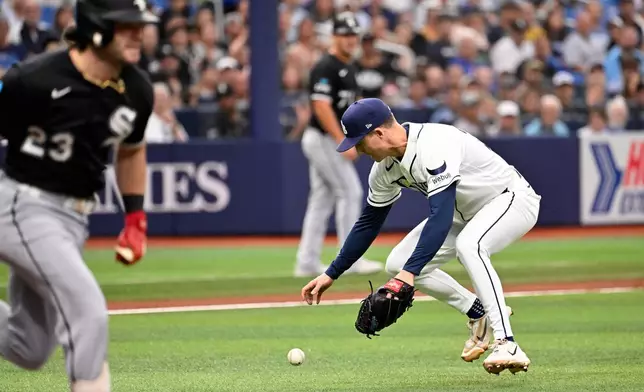 Chicago White Sox's Andrew Benintendi, left, runs to first base on a fielding error by Tampa Bay Rays pitcher Griffin Jax, right, during the first inning of a baseball game Sunday, Aug. 2, 2026, in St. Petersburg, Fla. (AP Photo/Jason Behnken)