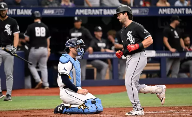 Tampa Bay Rays catcher Nick Fortes, center left, waits as Chicago White Sox's Andrew Benintendi, right, crosses the plate after hitting a home run during the fourth inning of a baseball game Sunday, Aug. 2, 2026, in St. Petersburg, Fla. (AP Photo/Jason Behnken)