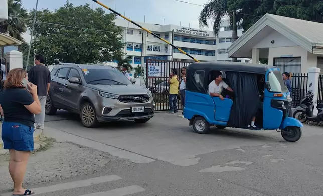 Vehicles exit the Ateneo de Zamboanga University following a shooting incident in Zamboanga, southern Philippines Tuesday, Aug. 18, 2026. (AP Photo) CORRECTION: Corrects date and day