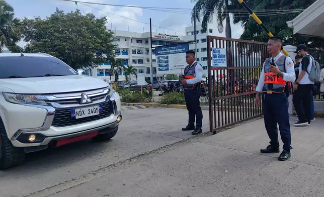 Security guards keep watch as vehicles exit the Ateneo de Zamboanga University following a shooting incident in Zamboanga, southern Philippines Tuesday, Aug. 18, 2026. (AP Photo)
