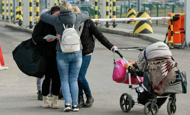 FILE - Family members hug as they reunite, after fleeing conflict in Ukraine, at the Medyka border crossing, in Poland, Sunday, Feb. 27, 2022. (AP Photo/Visar Kryeziu, File)