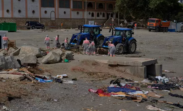 Cleaning staff clear the El Trampolin beach, where migrants who crossed from Morocco into Spain stayed in the Spanish exlave of Ceuta, Thursday, Aug. 20, 2026. (AP Photo/Antonio Sempere)