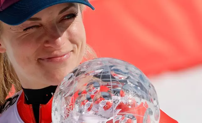 FILE - Switzerland's Lara Gut Behrami holds the trophy for the alpine ski, women's World Cup super-G discipline, in Saalbach, Austria, Friday, March 22, 2024. (AP Photo/Alessandro Trovati, File)