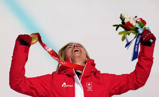 FILE - Lara Gut-Behrami, of Switzerland celebrates during the medal ceremony after winning the gold medal in the women's super-G at the 2022 Winter Olympics, Friday, Feb. 11, 2022, in the Yanqing district of Beijing. (AP Photo/Luca Bruno, File)