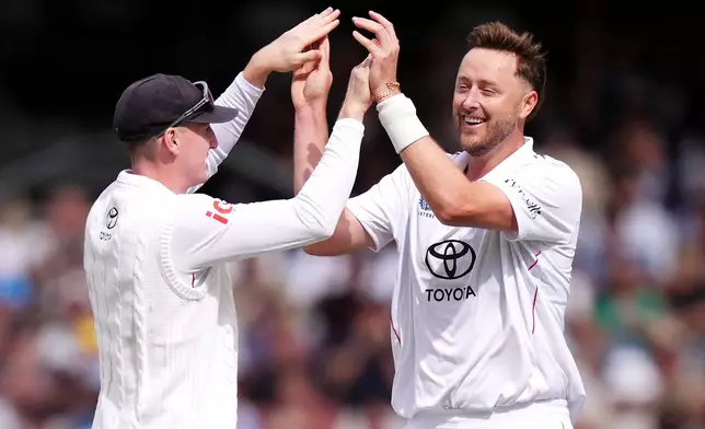 England's Ollie Robinson, right, celebrates bowling out Pakistan's Azan Awais on day one of the first Rothesay Test match between England and Pakistan in Leeds, England, Wednesday, Aug. 19, 2026. (Mike Egerton/PA via AP)