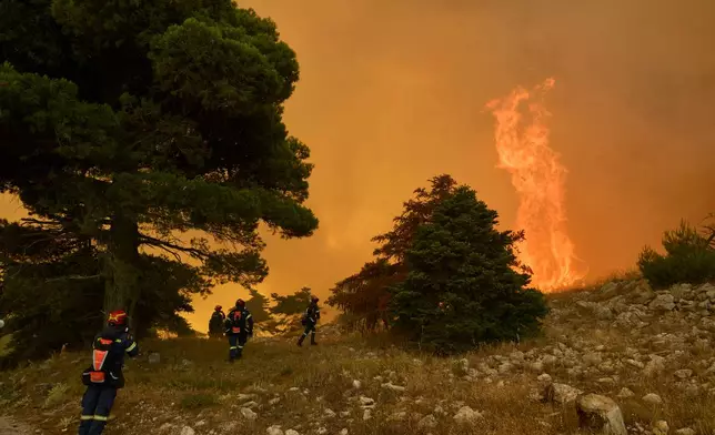 FILE - Firefighters approach towering flames on Mount Kithairon near Porto Germeno, northwest of Athens, Greece, Aug. 3, 2026. (AP Photo/Petros Giannakouris, File)