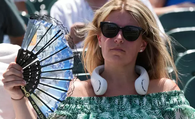 FILE - A baseball fan cools off before a game between the San Diego Padres and the Chicago Cubs in Chicago, July 1, 2026. (AP Photo/Nam Y. Huh, File)