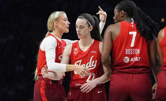Indiana Fever guards Sophie Cunningham, left, Caitlin Clark (22) and center Aliyah Boston (7) stand on the court during the first half of a WNBA basketball game against the Minnesota Lynx, Sunday, Aug. 2, 2026, in Minneapolis. (AP Photo/Abbie Parr)