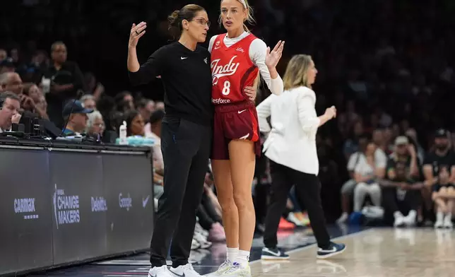 Indiana Fever head coach Stephanie White, left, and guard Sophie Cunningham (8) talk during the first half of a WNBA basketball game against the Minnesota Lynx, Sunday, Aug. 2, 2026, in Minneapolis. (AP Photo/Abbie Parr)