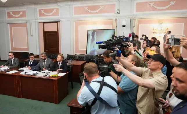 Yabloko party leader Nikolai Rybakov, right at the table, and his lawyers, left of him, attend a hearing on a lawsuit to bar the party from the upcoming parliamentary elections, at the Russia's Supreme Court, in Moscow, Monday, Aug. 10, 2026. (AP Photo/Pavel Bednyakov)
