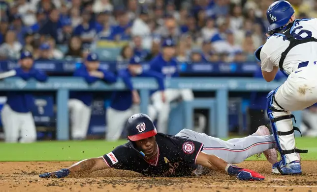 Washington Nationals' Daylen Lile, left, slides to score past Los Angeles Dodgers catcher Will Smith on a two-run double by Harry Ford during the fourth inning of a baseball game in Los Angeles, Sunday, Sept. 6, 2026. (AP Photo/Kyusung Gong)