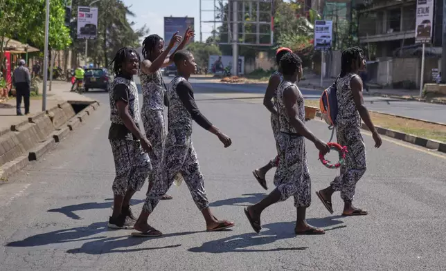Acrobats cross a busy street as they perform in traffic in Nairobi, Kenya, Wednesday, Aug. 26, 2026. (AP Photo/Brian Inganga)