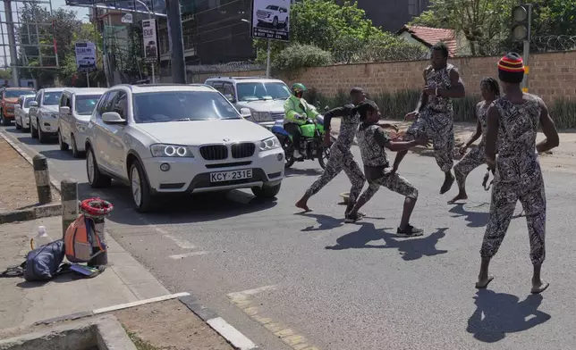 Acrobats perform in a busy street amid by traffic in Nairobi, Kenya, Thursday, Aug. 27, 2026. (AP Photo/Brian Inganga)