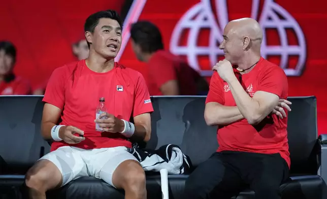 Team World's Brandon Nakashima, left, speaks to Team World captain Andre Agassi at a change of ends as he plays against Team Europe's Jakub Mensik during a Laver Cup tennis tournament match in London, Friday, Sept. 25, 2026. (AP Photo/Maja Smiejkowska)