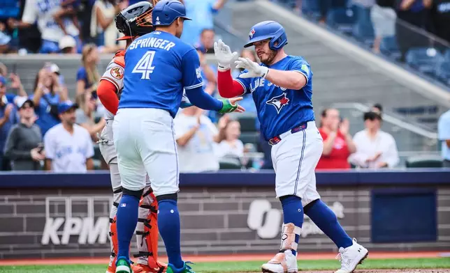 Toronto Blue Jays' Alejandro Kirk (30), right, celebrates his two run home run with George Springer (4) during third inning a baseball game against the Baltimore Orioles in Toronto, on Saturday, Sept. 12, 2026. (Sammy Kogan/The Canadian Press via AP)