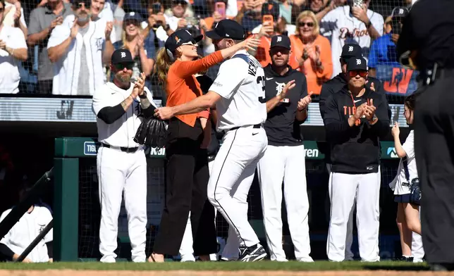 Kate Upton, left foreground, hugs her husband, Detroit Tigers starting pitcher Justin Verlander, after he was taken out of the game during the sixth inning of a baseball game against the Pittsburgh Pirates, Saturday, Sept. 26, 2026, in Detroit. (AP Photo/Jose Juarez)