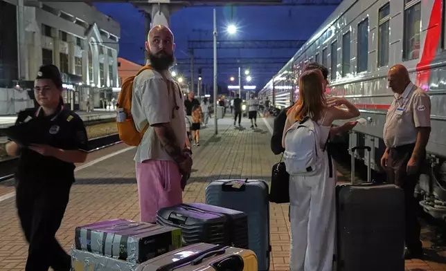 A 28-year-old digital content marketer who decided to leave Russia stands near his packed belongings at the railway station in Krasnodar, Russia, on Saturday, Aug. 29, 2026. He asked not to be identified because of security concerns. (AP Photo)