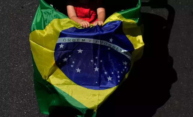 A child holds a Brazilian flag during an election campaign march in support of Brazilian President Luiz Inacio Lula da Silva, who is running for reelection, in Brasilia, Brazil, Sunday, Sept. 13, 2026. (AP Photo/Eraldo Peres)