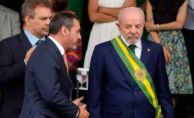 Brazilian President Luiz Inacio Lula da Silva, right, speaks with Federal Police Director General Andrei Rodrigues, center, next to Justice Minister Wellington Cesar, far left, during Independence Day celebrations in Brasilia, Brazil, Monday, Sept. 7, 2026. (AP Photo/Eraldo Peres)