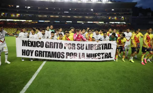 Players of Atletico Morelia and Leones Negros hold a sign that reads, "Mexico shouted for its freedom. Today, we shout for ours," before a Mexican second-division soccer match in Morelia, Michoacan state, Mexico, Saturday, Sept. 19, 2026. (AP Photo/Armando Solis)