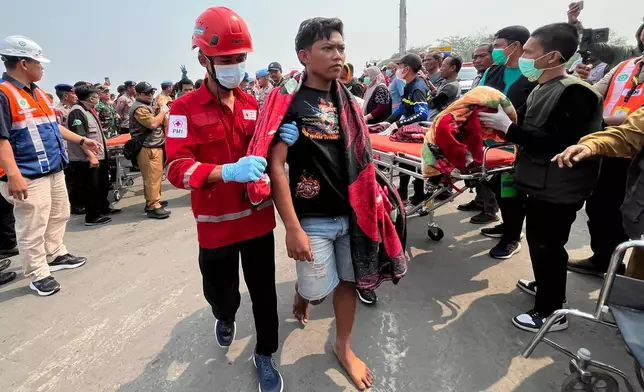 In this photo taken with a smartphone, survivors from a passenger ferry overturned in bad weather in the Java Sea arrive at a port in Banjarmasin, South Kalimantan, Indonesia, Tuesday, Sept. 15, 2026. (AP Photo/Iman Satria)