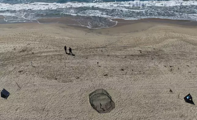 This aerial view shows a protective fence surrounding a sea turtle nesting site on the beach in Huntington Beach, Calif., Tuesday, Sept. 22, 2026. (AP Photo/Jae C. Hong)