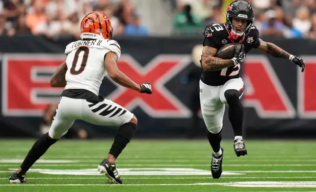 Cincinnati Bengals cornerback DJ Turner II (0) moves in on the play as Houston Texans wide receiver Jaylin Noel (13) runs with the ball during the first half of an NFL football game in Houston, Sunday, Sept. 20, 2026. (AP Photo/Ashley Landis)