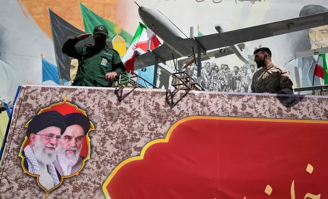 A member of Iran's Revolutionary Guard salutes while riding on a float displaying drones during the state-organized "Janfada," or "Sacrifice for Iran," military-style parade in Tehran, Iran, Friday, Sept. 18, 2026. (AP Photo/Vahid Salemi)
