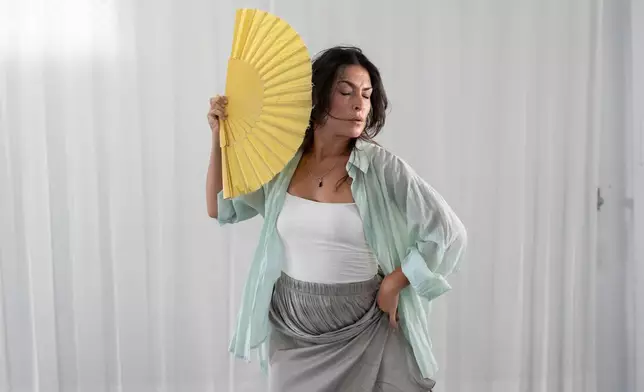 Carmen Torres, a professional flamenco dancer, rehearses a guajira, a flamenco style that traditionally incorporates the use of a fan, in Seville, Spain, on Aug. 27, 2026. (AP Photo/Laura Leon)