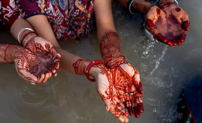 Hindu devotees perform evening rituals to the Sun god during the Hartalika Teej festival at the Sangam, the confluence of rivers Ganges, Yamuna and mythical Saraswati, in Prayagraj, in the northern Indian state of Uttar Pradesh, Monday, Sept. 14, 2026. (AP Photo/Rajesh Kumar Singh)