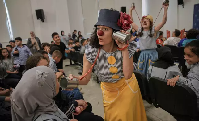 Members of the "Clown Me In" group perform for schoolchildren to raise awareness about the dangers of land mines and unexploded ordnance, during an event organized by the International Committee of the Red Cross in the village of Burj al-Shemali, southern Lebanon, Monday, Sept. 14, 2026. (AP Photo/Hassan Ammar)