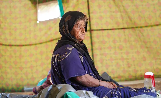 Salma Mohammed, 60, a displaced Yemeni woman, sits inside her tent at the Al-Firdaws camp in Ras Imran, just outside Aden, Yemen, Monday, Sept. 14, 2026. (AP Photo/Abdulnasser Alseddik)
