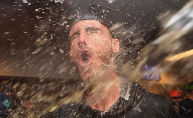 New York Yankees' Cody Bellinger celebrates with teammates after they clinched the playoffs in a baseball game against the Minnesota Twins, Monday, Sept. 14, 2026, in Minneapolis. (AP Photo/Abbie Parr)
