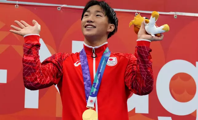 Gold medalist Shin Ohashi of Japan poses on the podium after the men's 200-meter breaststroke final in swimming at the Asian Games in Tokyo, Japan, Thursday, Sept. 24, 2026. (AP Photo/Hiro Komae)