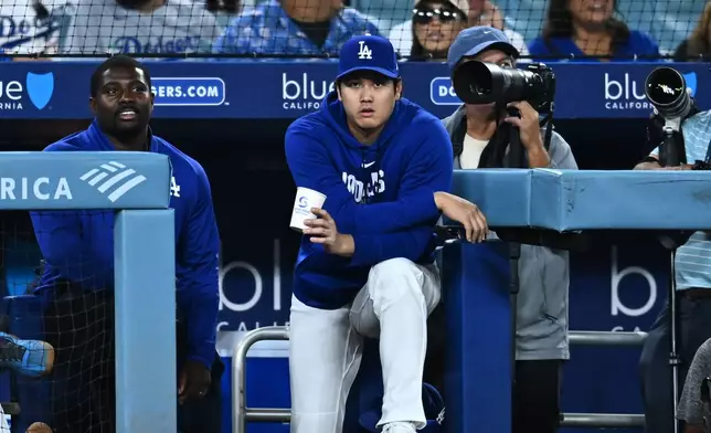 Los Angeles Dodgers' Shohei Ohtani, center, looks on during the eighth inning of a baseball game against the Washington Nationals, Friday, Sept. 4, 2026, in Los Angeles. (AP Photo/William Liang)