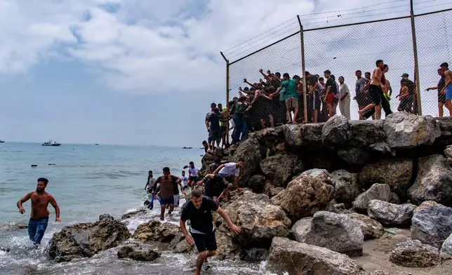 FILE - Migrants cross from Morocco into the Spanish enclave of Ceuta, Thursday, July 30, 2026. (AP Photo/Antonio Sempere, File)