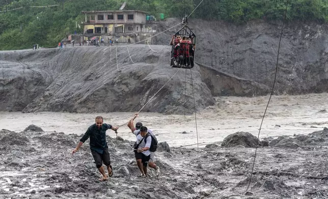 Residents pull a newly installed zipline to help people commute across the Trishuli river in the aftermath of flash floods at Bidur in Nepal's Nuwakot district, Nepal, Wednesday, Sept. 2, 2026. (AP Photo/Rajesh Kumar Singh)